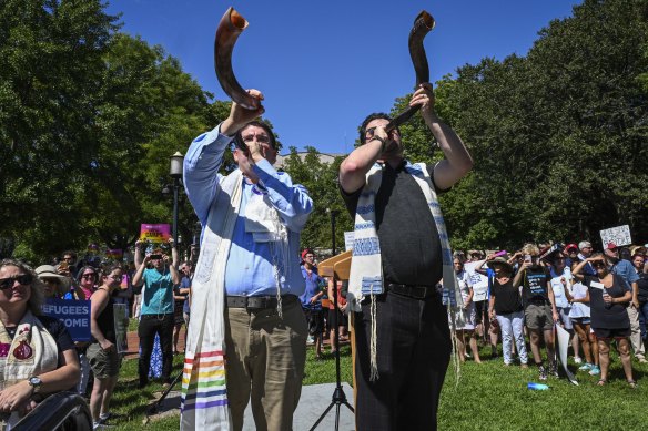 Rabbi Joshua Fixler, right, of congregation Emmanuel in Houston, and cantor Jason Kaufman of Bethel Hebrew congregation of Alexandria, Virginia, face the White House and blow shofars (ram's horns) as Jewish, interfaith and immigrant groups rally to commemorate the Jewish day of mourning by calling on the Trump administration to change its immigration policies.