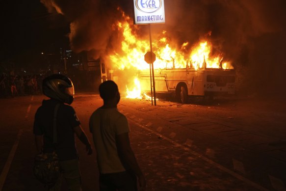 Protesters watch as a bus is set on fire outside the presidence’s residence on April 1.