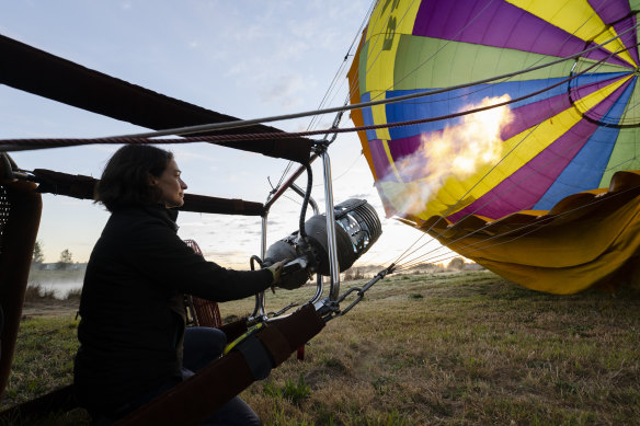 Pilot Nicola Scaife inflates the balloon with the propane burner before take-off in the Hunter Valley.