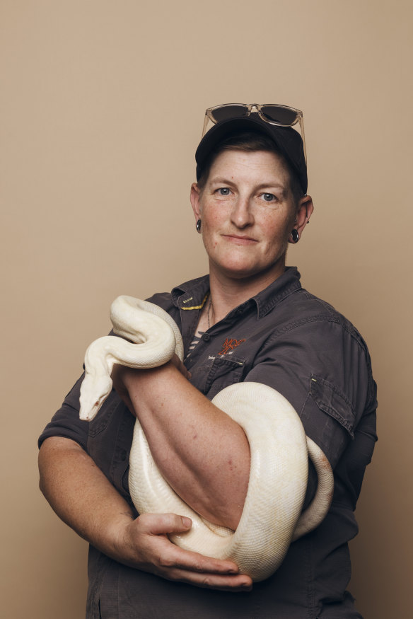 Zookeeper Fran Campbell with an albino red-tailed boa constrictor. 