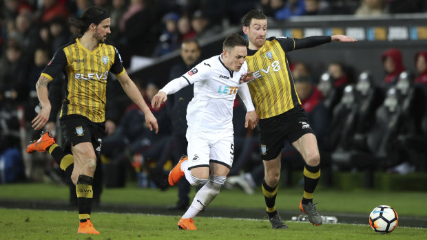 Big win: Swansea City's Connor Roberts and Sheffield Wednesday's David Jones battle for the ball.