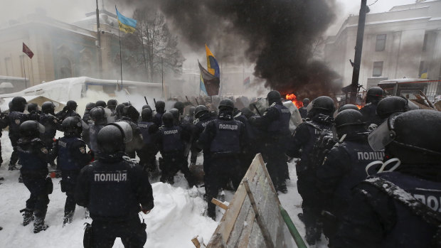 Riot police destroy a tent camp installed by activists of the Movement of New Forces, the political party led by Mikheil Saakashvili, as protesters burned tyres in Kiev, Ukraine early on Saturday.