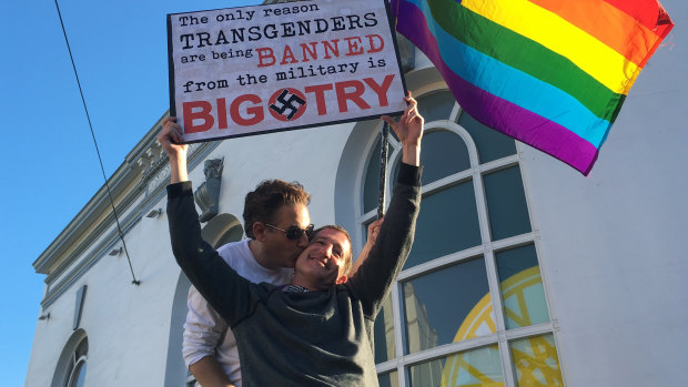 Nick Rondoletto, left, and Doug Thorogood, a couple from San Francisco, wave a rainbow flag and hold a sign against a proposed ban of transgender people in the military at a protest in July 2017.</p>
<p>