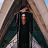 Pictured is Bangarra dancer Courtney Radford on top of one of the Opera House sails in full costume, early this morning.