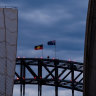 The Aboriginal flag flies atop the Sydney Harbour Bridge on Australia Day 2021.