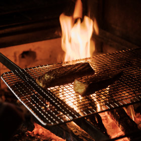 The small open kitchen has a woodfire oven. 