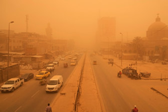 People navigate a street during a sandstorm in Baghdad, Iraq.