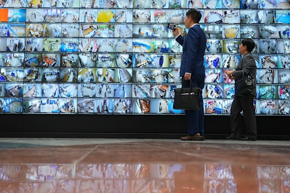 People look at a screen installed in Russia’s Central Election Commission showing a live feed from polling stations.