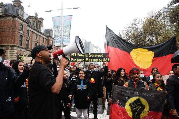 Noongar dancer Derek Nannup leads the crowd of protesters in a march through the CBD.  