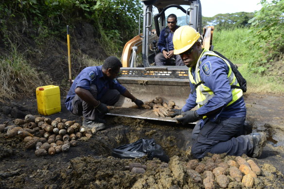 A Solomon Islands police explosive ordnance disposal (EOD) team prepare to detonate artillery rounds, hand grenades and other munitions during clearance operations in 2018.