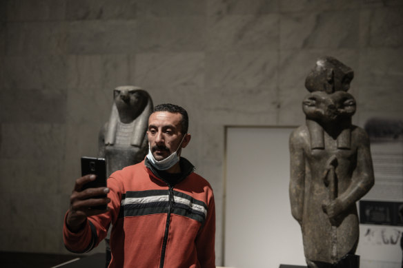 A visitor takes a selfie with pharaonic statues inside the new National Museum of Egyptian Civilisation in Cairo. The new museum has opened its  doors ahead of launching a display of 22 royal mummies that were previously housed in the Egyptian Museum near Tahrir Square.