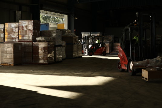 Forklifts load goods onto trucks at the Glen Cameron Group distribution centre.