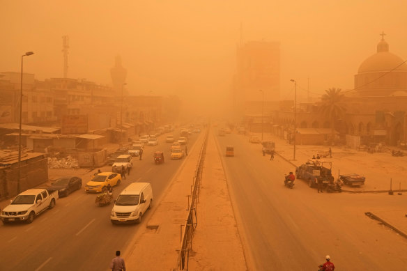 People navigate a street during a sandstorm in Baghdad, Iraq.