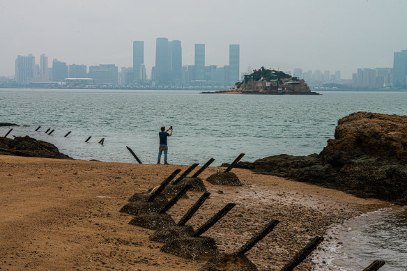 A tourist on Lion Rock, the closest of Taiwan’s territory to China. Around him are anti-landing spikes. Behind is the Chinese city of Xiamen, just 3km to the west. 