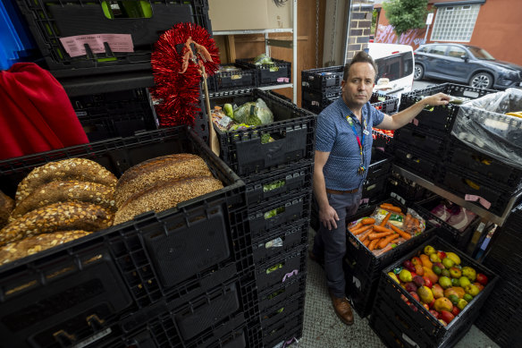 Manager Chris Sprake stands with crates of bread, carrots and fruit. The food, distributed on Thursdays, always runs out within a few hours. 