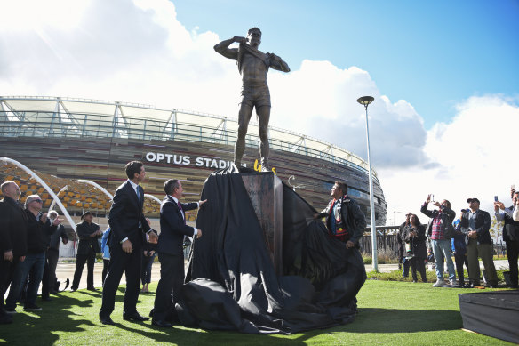 Winmar, right, AFL chief executive Gillon McLachlan, and WA Premier Mark McGowan unveil the statue of the player outside Optus Stadium in Perth.