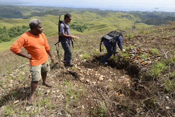 Willy Basi, a village elder from Mt Austin, guides members of the Royal Solomon Islands explosive ordnance disposal (EOD) team to a cache of 69 American mortars on site since 1942. The mortars are primed and ready to detonate. 