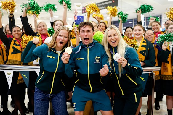 Winter Olympians Daisy Thomas, Cooper Woods and Danielle Scott pose for a photo with supporters at Sydney International Airport on Thursday morning. 