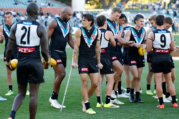 An injured Connor Rozee with teammates.