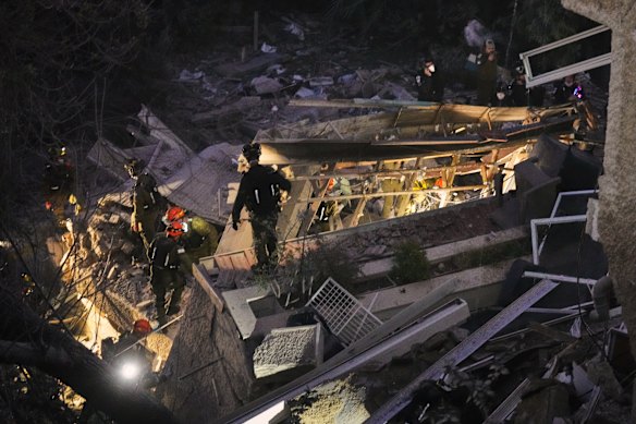 Israeli security forces and rescue teams work amid the rubble of a residential building hit by an Iranian missile in Haifa, Israel on Sunday.
