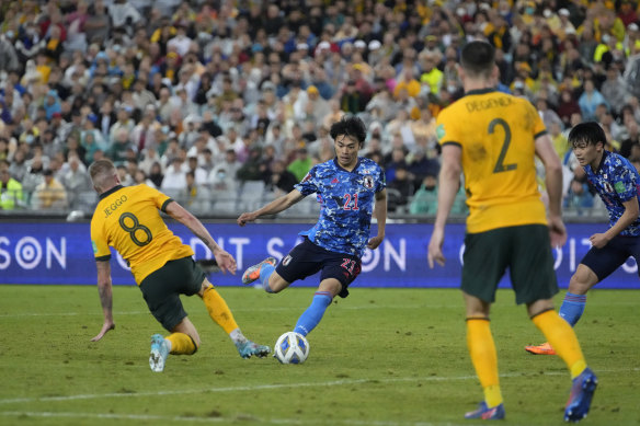 Japan’s Kaoru Mitoma moves past Australia’s James Jeggo to score a goal.