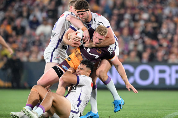 Thomas Flegler of the Broncos is tackled by Storm defenders.