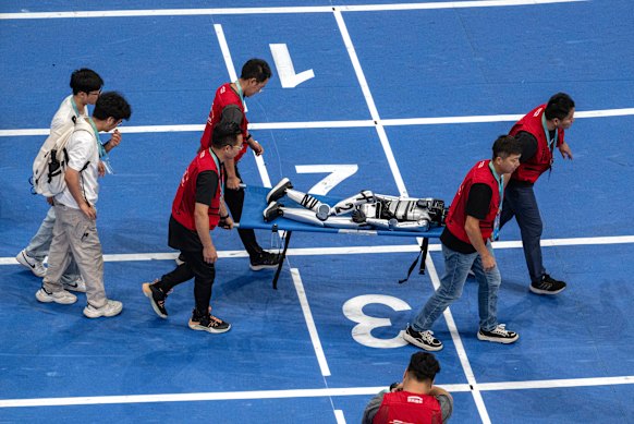 A fallen humanoid is recovered from the track. 