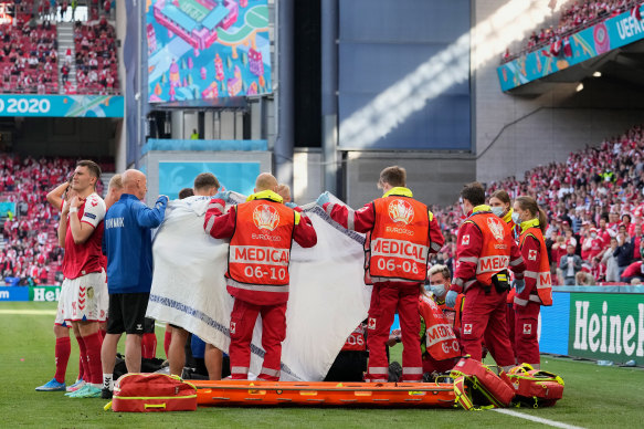 Medics and the Danish soccer team surround Christian Eriksen on the pitch after he suffered a medical emergency.