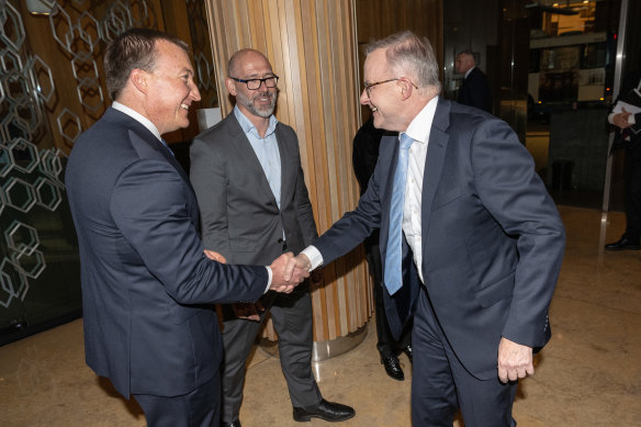 The Business Council of Australia’s incoming chief executive Bran Black shakes hands with the prime minister, as BCA president Tim Reed watches on.