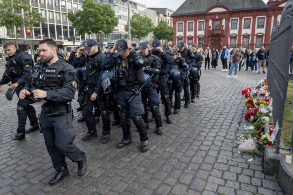 German police officers commemorate a colleague in Mannheim Germany, after learning that a police officer, who was stabbed two days ago there has died on Sunday.