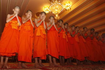 The Wild Boars pray during a ceremony marking the completion of their service as novice Buddhist monks.