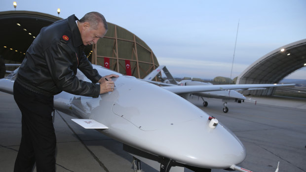 Turkey's President Recep Tayyip Erdogan signs a drone at a military airbase in Batman, Turkey, on Saturday.