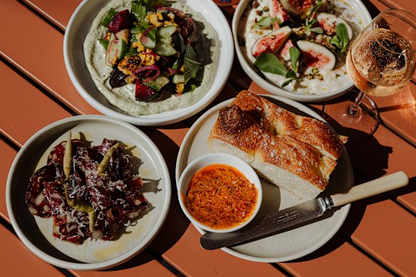 Clockwise from bottom left: Wild kangaroo salami; grilled corn with plum and macadamia green goddess sauce; figs with stracciatella, purslace, vincotto and pistachio; and focaccia and harissa butter..