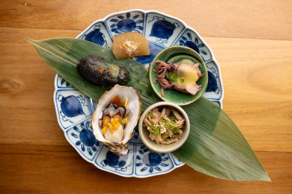 Appetiser plate with oyster, eggplant, fairy squid, steamed chicken.