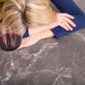 Depressed woman with wine glass resting her head on kitchen counter Talking Wine, wine additives story for Good Food Mag Online Feb 2020 iStock photo