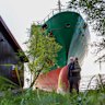 Johan Helberg stands next to his house with a new addition, the container vessel NCL Salten.