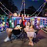 James and Kerryn Drmic, and daughters Zadie (in red) and Pia,outside their Christmas lights display.