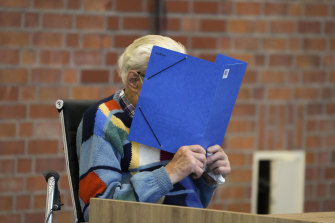 The accused Josef S. covers his face as he sits in the courtroom in Brandenburg, Germany, 