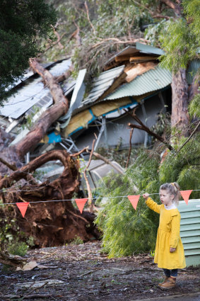 Mirrah, 6, looks at the damage after three huge trees landed on the roof of the Monbulk Aquatic Centre, where she was planning have her birthday party next week. 