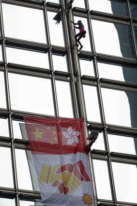 French 'spiderman' climber Alain Robert scaled a 68-storey skyscraper in Hong Kong on Friday to hoist a flag symbolising reconciliation between China and the territory.