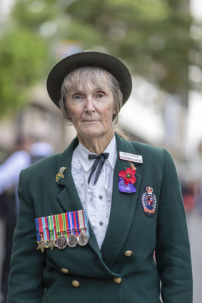 Sandra Davis poses with her father's war medals during the Anzac Day parade in Brisbane on Thursday.