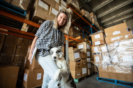 Silvia Hill and her most valuable employee at their warehouse workplace, Luna the Border Collie.