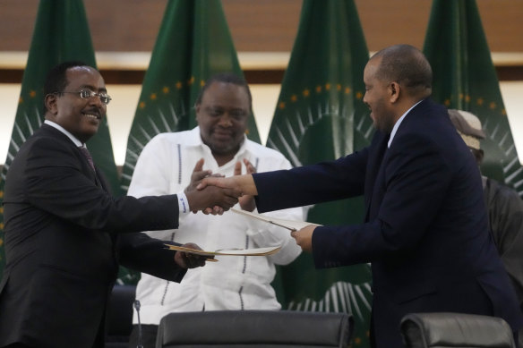 Lead negotiator for Ethiopia’s government, Redwan Hussein, left, shakes hands with lead Tigray negotiator Getachew Reda, as Kenya’s former president, Uhuru Kenyatta looks on, after the peace talks in Pretoria, South Africa.