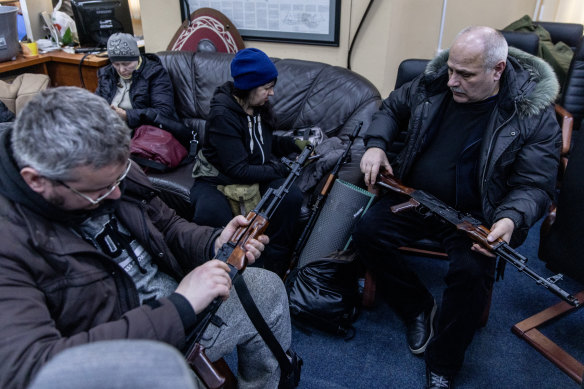 Civilian volunteers check their guns at a  territorial defence unit registration office in Kyiv on February 26.