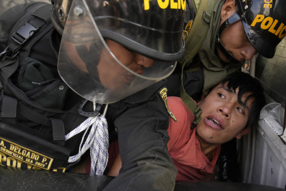 An anti-government protesters who traveled to the capital from across the country to march against Peruvian President Dina Boluarte, is detained and thrown on the back of police vehicle during clashes in Lima.