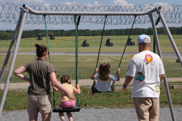 Children swing on a playground as Patriot air defence missile systems stand in the background at Vilnius International Airport ahead of the NATO summit in Lithuania.