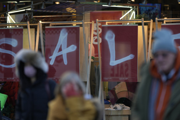 Shoppers on Oxford Street walk past a sale sign in a shop window after the Bank of England has raised its key Base Rate again.