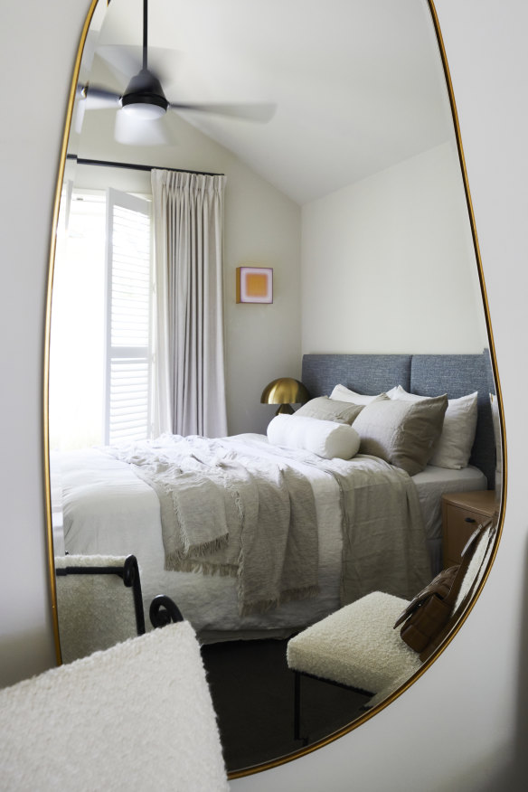 A brass mirror from Melbourne design studio Middle of Nowhere reflects the tranquil main bedroom. The artwork is by Sydney artist Jonny Neische.