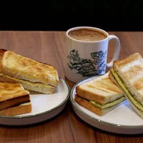 Pineapple bun toast with butter (left) and kaya butter toast (right) with Hainan-style kopi.
