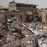 A man walks by a house hit in recent fighting in Khartoum.